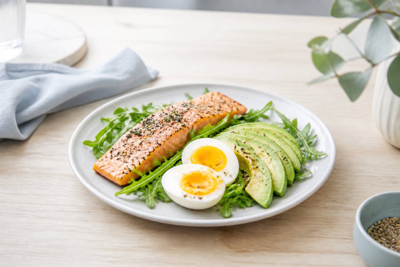 Assiette composée d'aliments cétogènes avec saumon, avocat et roquette
