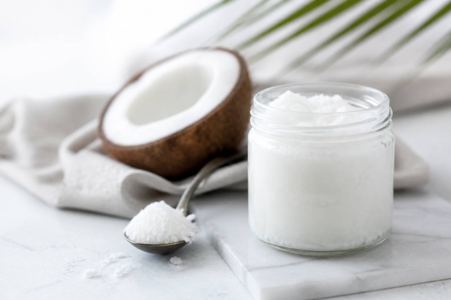 Petit pot d'huile de coco avec de la chair râpée à côté
