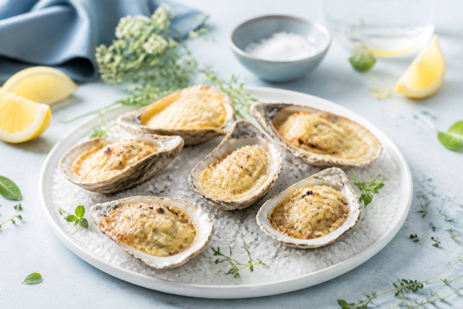 Plat d'huîtres gratinées au parmesan doré sur un lit de gros sel