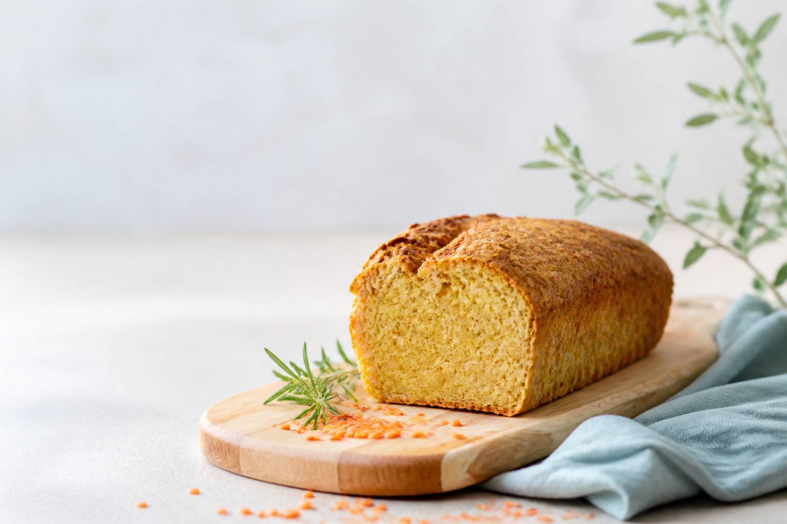 Pain aux lentilles corail doré sur une planche avec lentilles crues