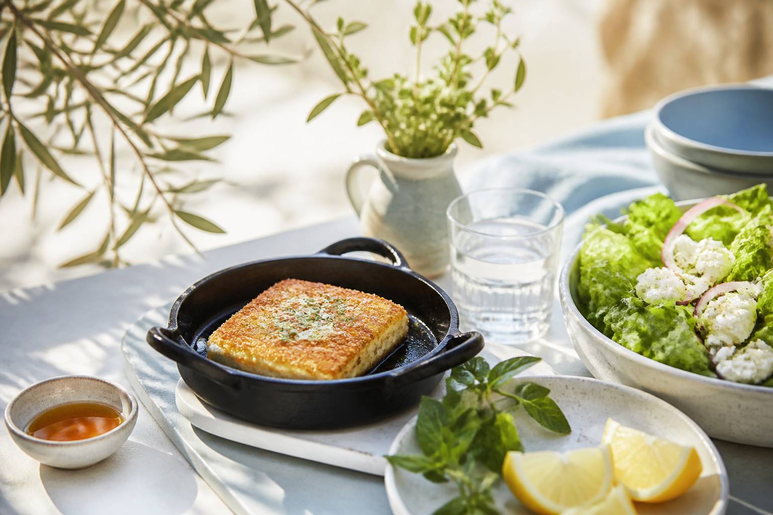 Feta panée dorée dans une poêle en fonte avec salade et citron